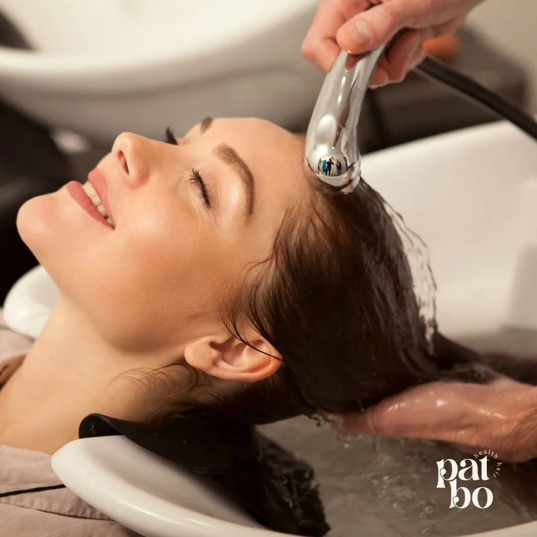 mulher sentada em lavatório lavando cabelo
